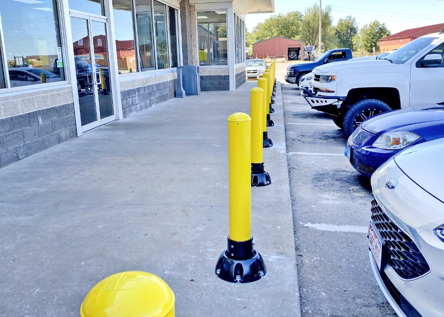 Yellow bollards in parking lot reduce potential hazards of vehicles entering storefront.